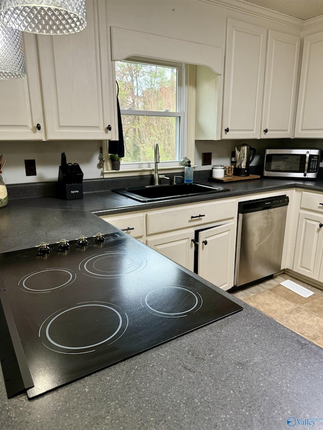 kitchen with stainless steel appliances, white cabinetry, and sink