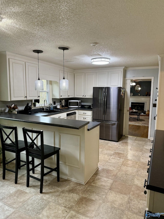 kitchen featuring white cabinets, a breakfast bar area, decorative light fixtures, kitchen peninsula, and stainless steel appliances