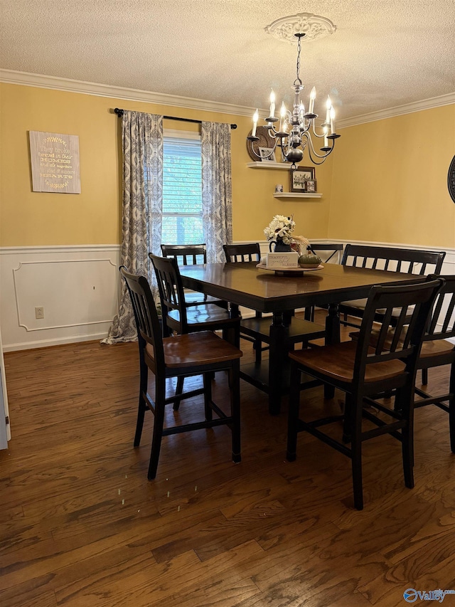 dining room featuring ornamental molding, a textured ceiling, dark wood-type flooring, and a chandelier