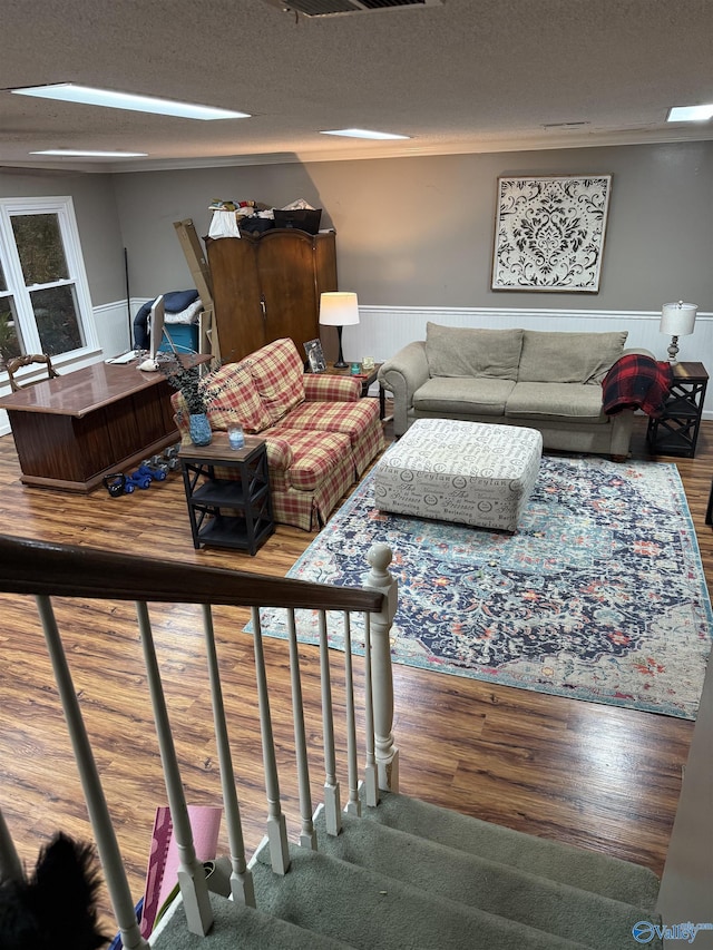 living room featuring wood-type flooring, a textured ceiling, and a skylight