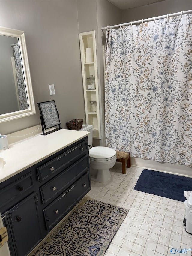 bathroom with tile patterned flooring, vanity, and toilet