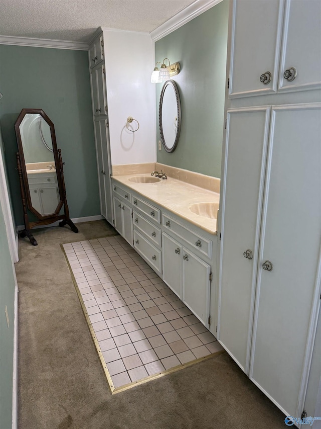 bathroom with a textured ceiling, vanity, tile patterned floors, and crown molding