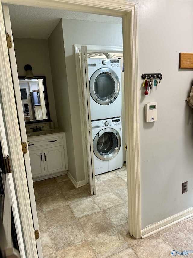 laundry area featuring a textured ceiling and stacked washer and clothes dryer