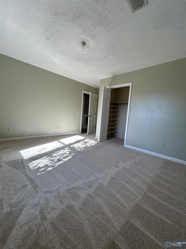 unfurnished bedroom featuring carpet flooring, a textured ceiling, and a closet