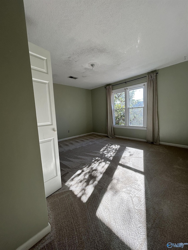 carpeted spare room featuring a textured ceiling