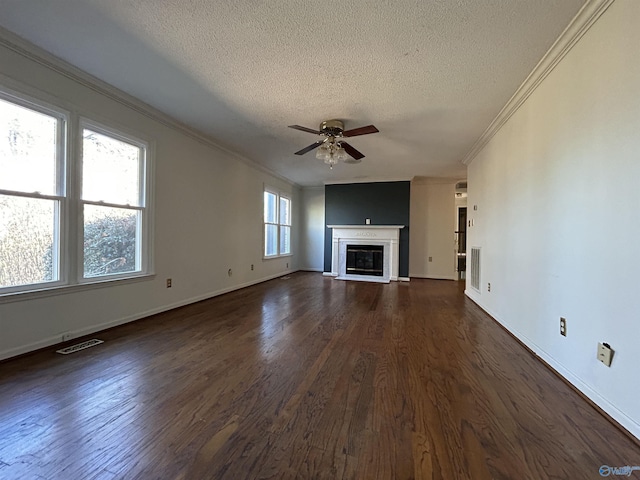 unfurnished living room with ceiling fan, dark hardwood / wood-style flooring, ornamental molding, and a textured ceiling