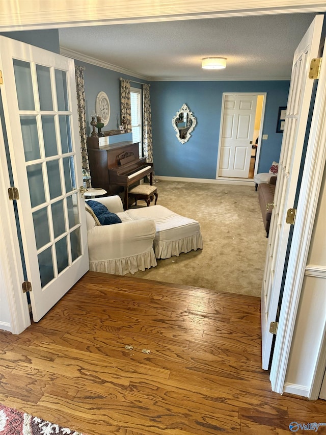 sitting room featuring a textured ceiling, carpet floors, and crown molding