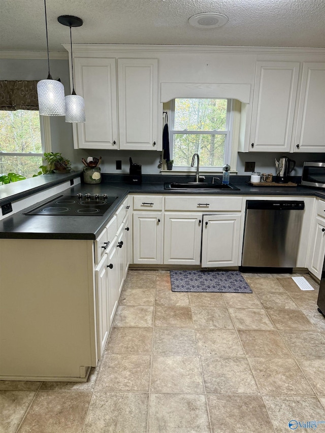 kitchen featuring sink, hanging light fixtures, a textured ceiling, white cabinets, and appliances with stainless steel finishes