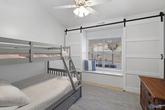 carpeted bedroom featuring ceiling fan, lofted ceiling, and a barn door