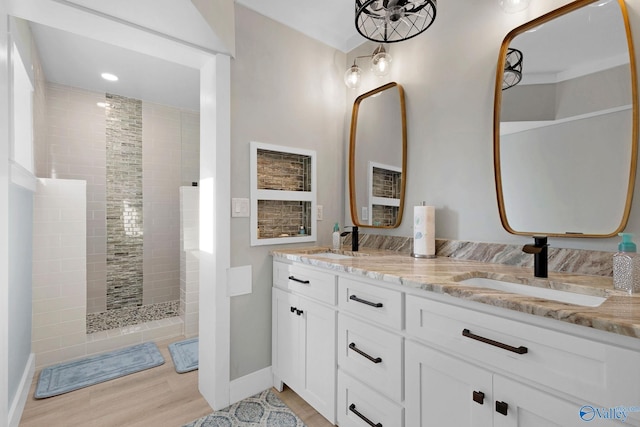 bathroom featuring vanity, a tile shower, and hardwood / wood-style flooring