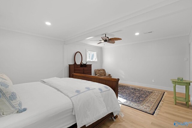 bedroom featuring ceiling fan, ornamental molding, and light hardwood / wood-style flooring