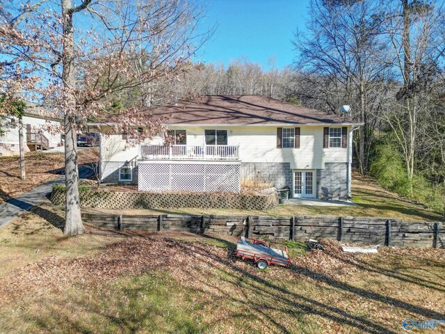 back of house featuring a wooden deck and a lawn