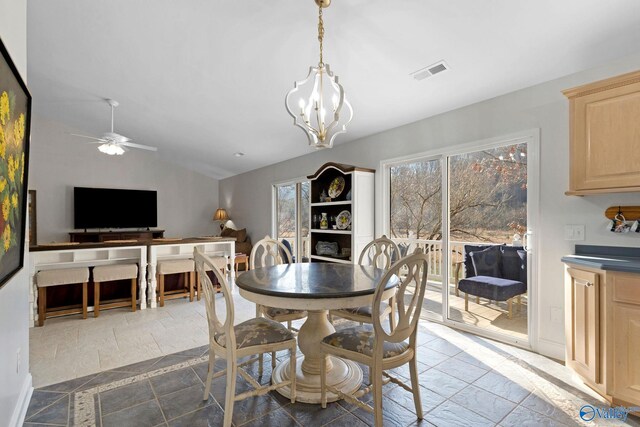 dining space with vaulted ceiling and ceiling fan with notable chandelier