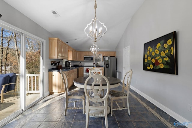 dining area featuring lofted ceiling and an inviting chandelier