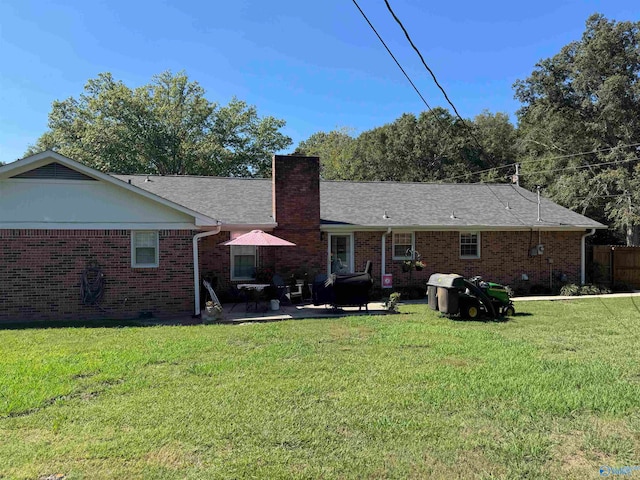 rear view of house with a yard and a patio