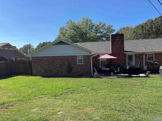 back of house with a patio area and a yard