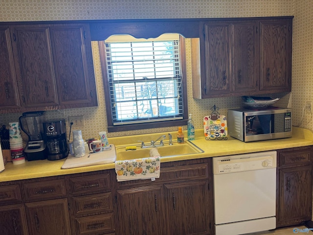 kitchen with dishwasher, dark brown cabinets, and sink