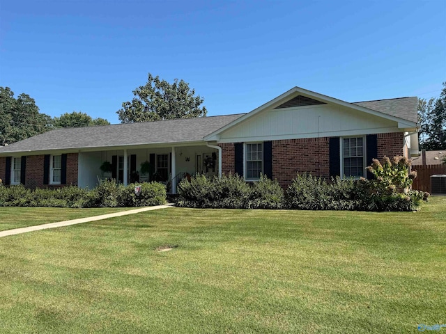 ranch-style home featuring cooling unit and a front yard