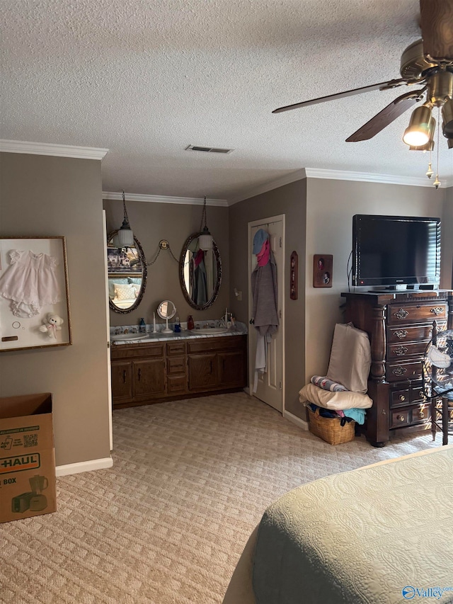 carpeted bedroom featuring a textured ceiling, ceiling fan, sink, and crown molding