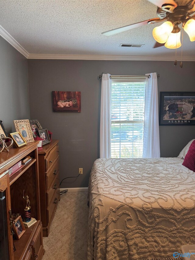 carpeted bedroom with a textured ceiling, ceiling fan, and crown molding