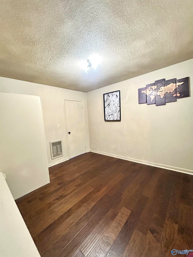 basement with dark wood-type flooring and a textured ceiling