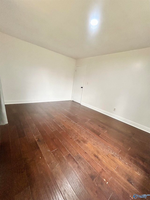 unfurnished room with dark hardwood / wood-style flooring