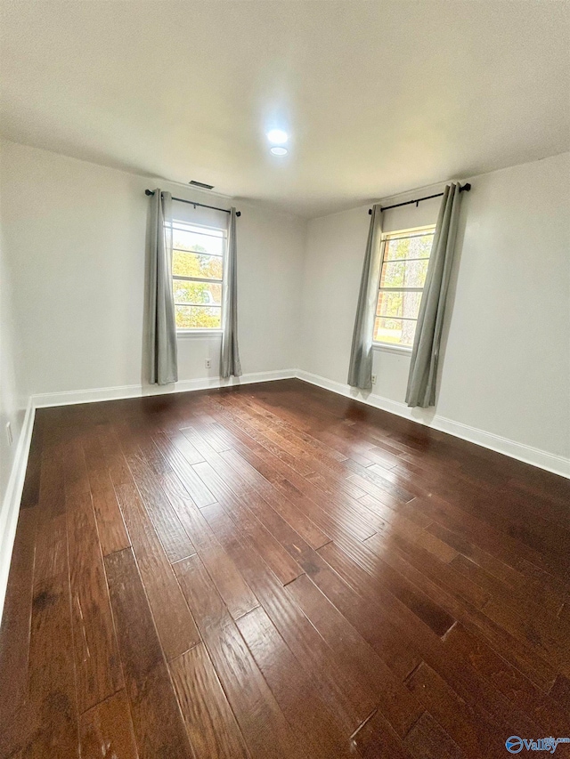 spare room featuring hardwood / wood-style flooring and a healthy amount of sunlight