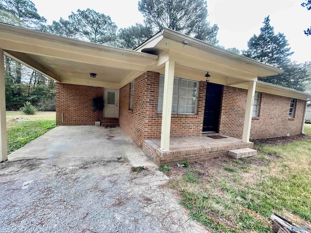 view of home's exterior with a porch and a carport