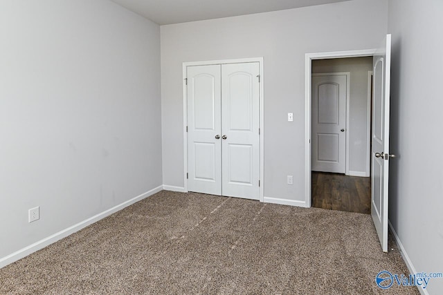 unfurnished bedroom featuring dark carpet and a closet