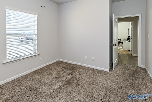 unfurnished room with dark carpet