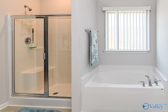 bathroom featuring shower with separate bathtub and a wealth of natural light