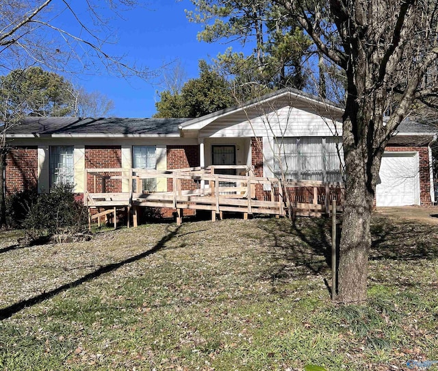 view of front of home featuring a wooden deck, a front lawn, and a garage