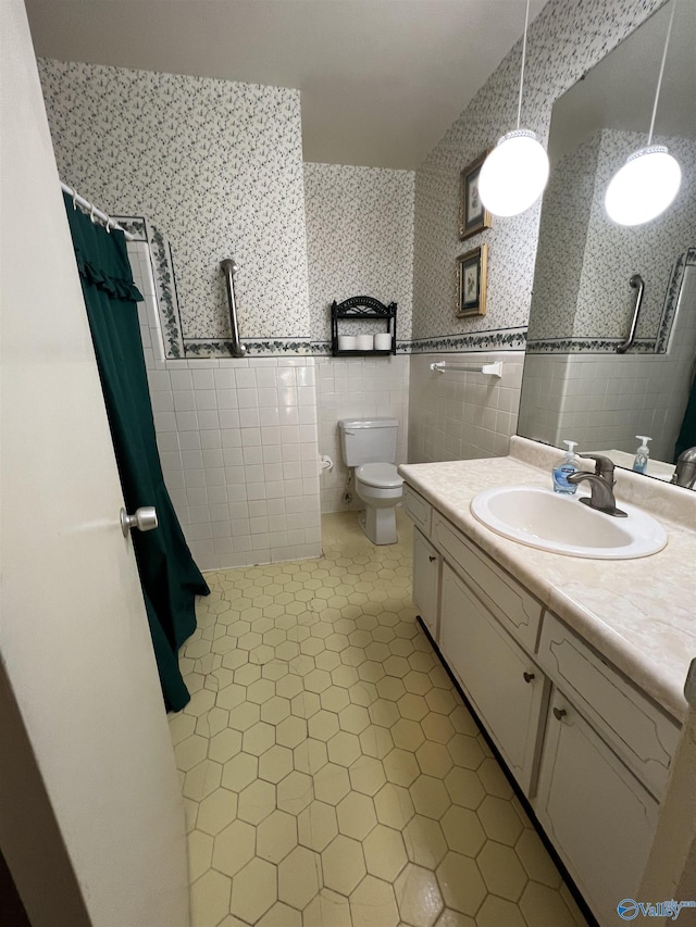 bathroom with toilet, vanity, tile patterned flooring, tile walls, and a shower with curtain