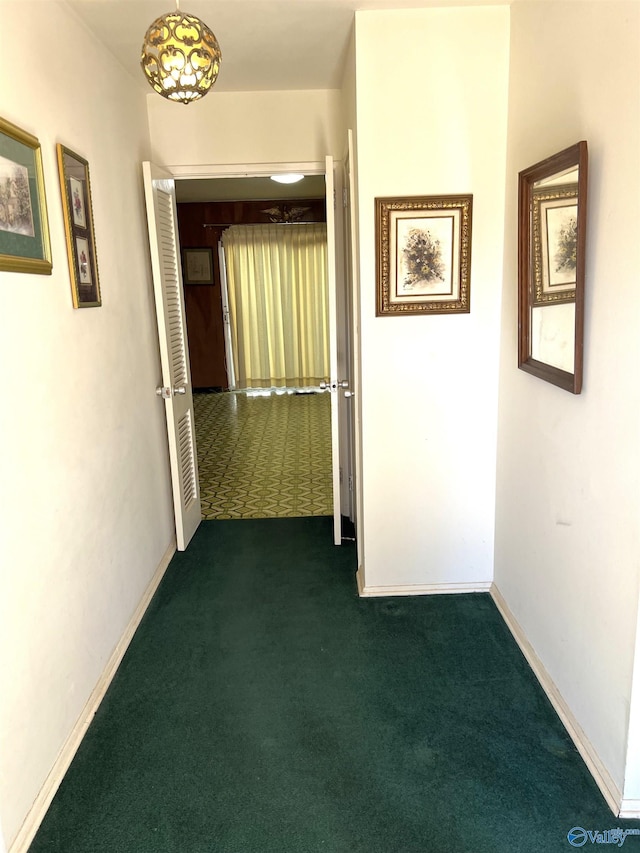 hallway with dark colored carpet