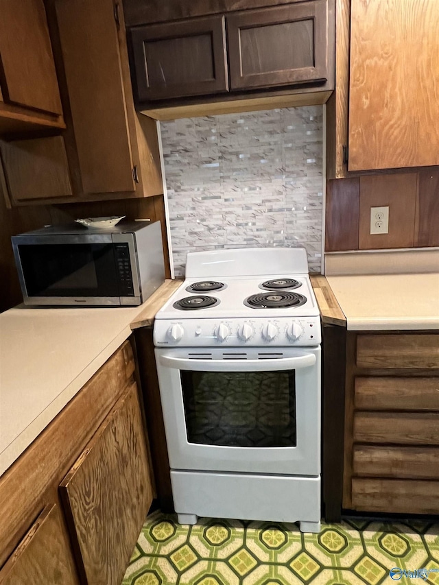 kitchen featuring white range with electric stovetop, backsplash, and dark brown cabinetry