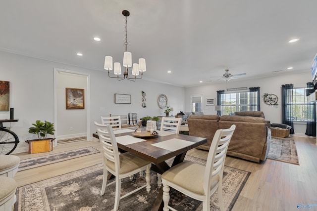 dining area featuring ceiling fan with notable chandelier, crown molding, and light hardwood / wood-style flooring