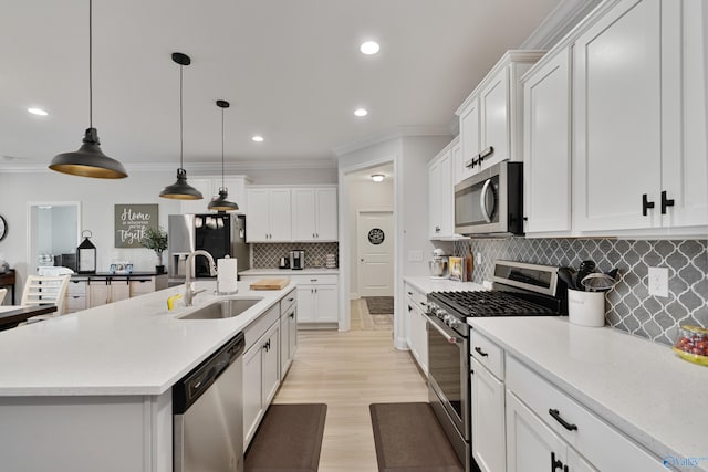 kitchen featuring sink, stainless steel appliances, pendant lighting, a center island with sink, and white cabinets