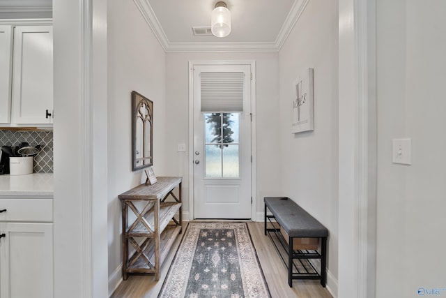 foyer entrance with crown molding and light hardwood / wood-style flooring