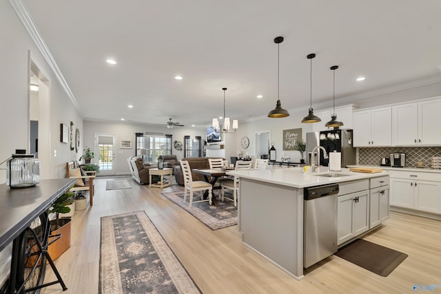 kitchen with white cabinets, appliances with stainless steel finishes, light hardwood / wood-style flooring, and sink