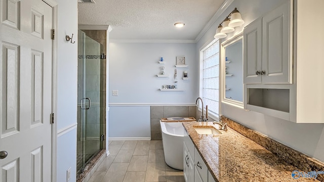 bathroom featuring separate shower and tub, a textured ceiling, tile walls, ornamental molding, and vanity