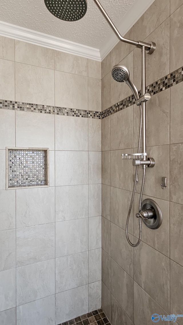 bathroom with a tile shower, crown molding, and a textured ceiling