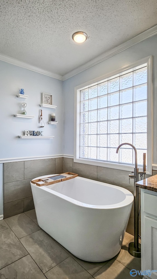 bathroom featuring vanity, a bathtub, and a textured ceiling