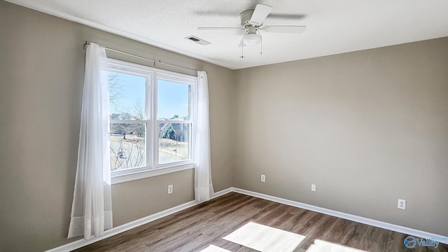 spare room featuring hardwood / wood-style flooring, a textured ceiling, and ceiling fan