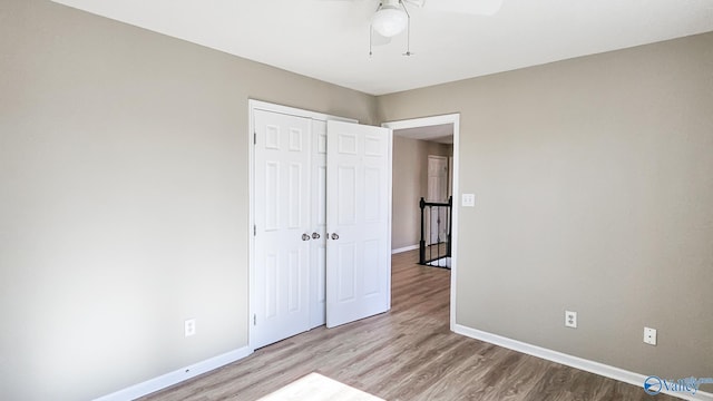 unfurnished bedroom with ceiling fan, a closet, and light hardwood / wood-style flooring