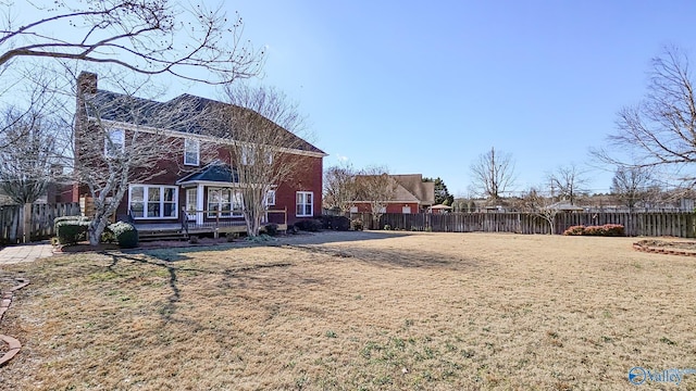 rear view of house featuring a wooden deck and a yard