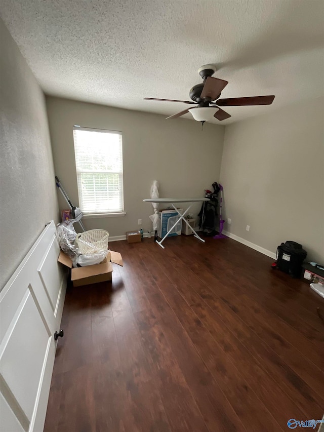 miscellaneous room featuring ceiling fan, a textured ceiling, and dark hardwood / wood-style floors