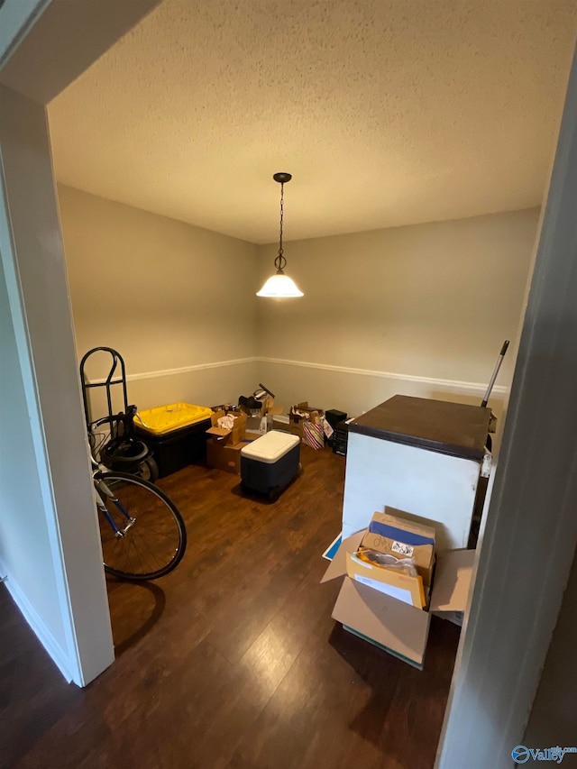 dining area featuring a textured ceiling and dark hardwood / wood-style flooring