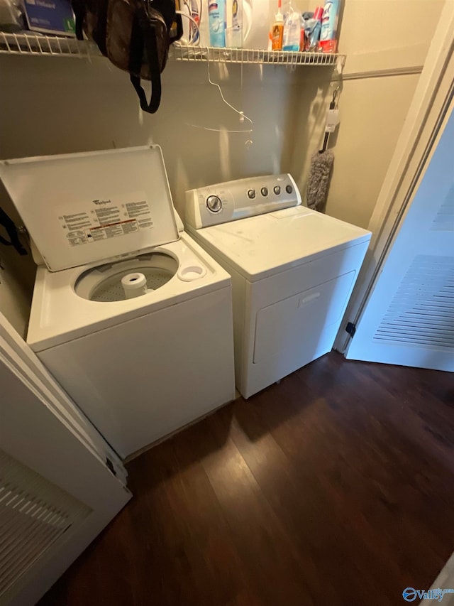 clothes washing area with washer and clothes dryer and dark hardwood / wood-style flooring