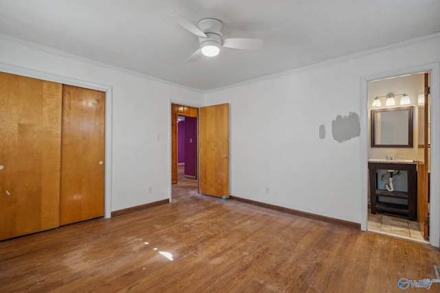 unfurnished bedroom featuring baseboards, ornamental molding, and wood finished floors