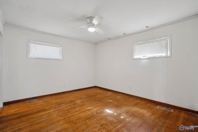 unfurnished room with baseboards, plenty of natural light, visible vents, and wood finished floors